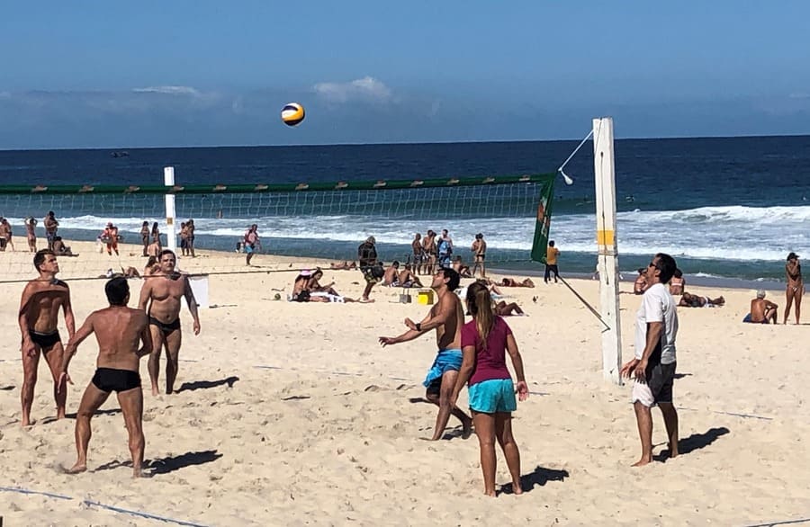 Friends playing sports at Ipanema Beach.