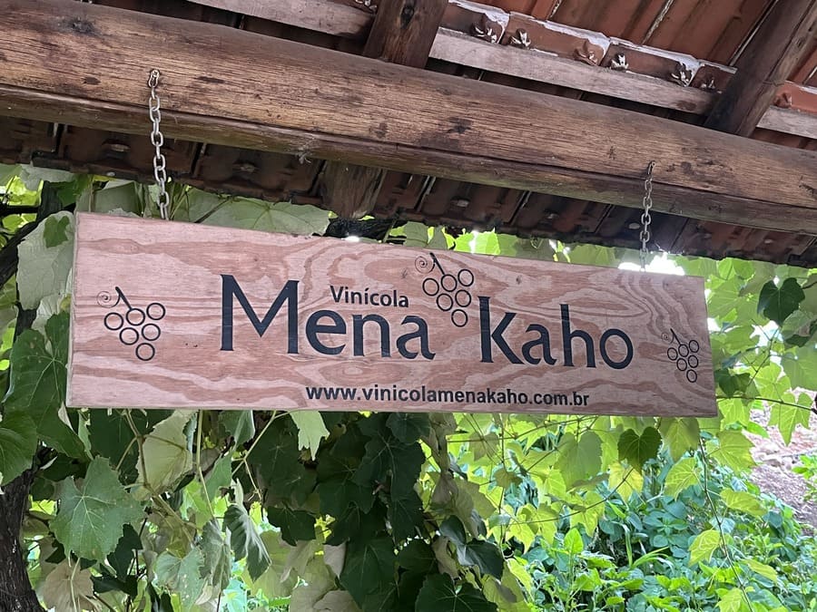 Placa da Vinícola Mena Kaho em meio aos vinhedos
